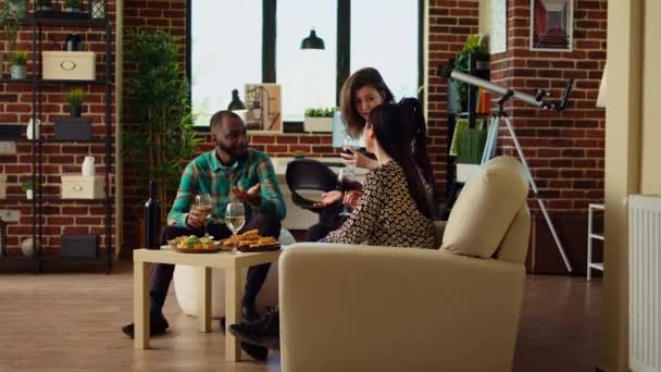 文化各异的一群人聊天 在朋友们的社交聚会上喝酒 非洲裔美国女人喜欢和伴侣聊天 一起玩乐 吃零食 — 图库视频影像