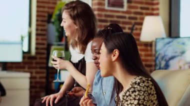 BIPOC 'lu kadınlar evlerindeki kanepede oturup, bir bardak şarap ve atıştırmalıkların tadını çıkarırken erkek arkadaşları hakkında dedikodu yapıyorlar. Çok ırklı arkadaşlar alkol içip tuğla duvarda sohbet ediyorlar.