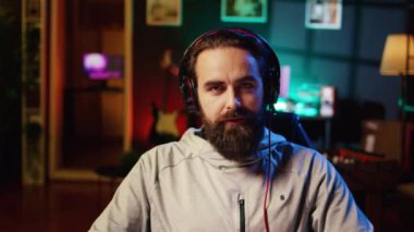 Seyircilerle canlı yayında esports online maçını kazandıktan sonra kutlama yapan neşeli profesyonel oyuncu. Seyirciler için yayın yaparken video oyununda galip geldikten sonra enerji dolu neşeli bir adam.