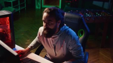 Evde video oyunu oynayan kızgın bir adam düşmanlar tarafından mağlup edildikten sonra kafasını klavyede eziyor. Çevrimiçi çoklu oyunculu esport maçını kazanamadığı için öfkelenen rekabetçi profesyonel oyuncu, sinirlendi