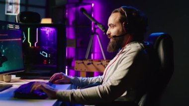 Oyuncu arkadaşlarıyla online çok oyunculu uzay gemisi video oyunu oynar, kulaklık mikrofonuyla konuşur. Oyuncuların takım arkadaşlarıyla konuşmalarına, uçan uzay araçlarına, boş zamanların tadını çıkarmalarına yakınlaş.
