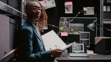 Afro-Amerikan ajanı delilleri inceledi ipuçları ve sabıka kayıtları ile çözdü, polis arşivinde çalıştı. Masanın yanında duran kadın kriminolog, harita panosuna bakıyor..