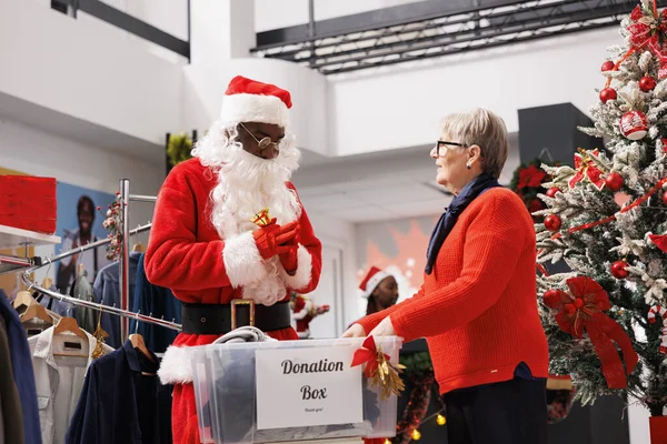 人们填写礼品盒 以帮助圣诞老人工人分发圣诞精神并捐赠给慈善机构 假期慷慨是指成年人为有需要的儿童收集衣服 — 图库照片