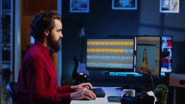 Mutlu fotoğrafçı bilgisayar ekranlarındaki görüntüleri düzenlemek için rötuş programını kullanıyor. Gülümseyen fotoğraf editörünün portresi yaratıcı stüdyo ofisindeki fotoğraflara renk notu veriyor.