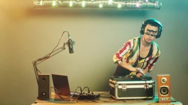 Havalı DJ sanatçı turntable 'larda müziği karıştırmak için vinil plak kullanıyor, elektronik kullanarak tekno melodilerin remixini yapıyor. Müzik seti ile karıştırma, partide performans sergileme. Üçayak atışı.