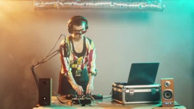 Kadın DJ, inanılmaz tekno albümleri karıştırdıktan sonra hayranlarına sevgilerini yolluyor. Genç sanatçı turntable ve disklerle yeni melodiler yaratıyor. Üçayak atışı.
