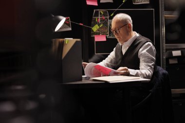 Karanlık odada masa başında oturan yaşlı bir özel dedektif suç davasında fazla mesai yapıyor. Kıdemli polis memuru kayıp kişi raporunu analiz ediyor, kanıt belgelerini kontrol ediyor.