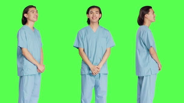 Asiatisk Manlig Sjuksköterska Poserar Studio Med Självförtroende Bär Sjukhusuniform Och — Stockvideo