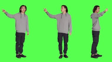 Stüdyoda sol veya sağ yönleri gösteren, her iki tarafı gösteren ve başka bir yolu gösteren bir model. Asyalı genç yetişkin birine şu tarafa gitmesini tavsiye ediyor, tüm vücudu yeşil perde arkaplanı.