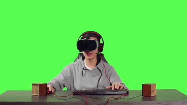 Pov的人坐在工作站上的全身绿屏上 和同事们一起享受虚拟现实的网络游戏 带着Vr眼镜的年轻成年人游戏 玩战斗游戏 — 图库视频影像