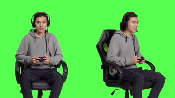 自信的家伙在工作室里玩电子游戏 在绿屏背景下和朋友们一起玩网络游戏 亚洲男子游戏玩家坐在椅子上享受Rpg比赛 — 图库视频影像