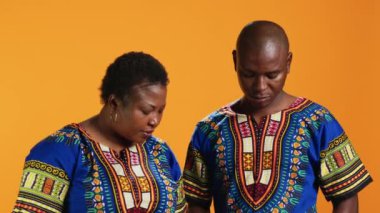 Akıllı telefondan kaydedilen neşeli evli çift modern melodilerle karaoke seansının tadını çıkarıyor. Afrikalı Amerikalı erkek ve kadın şarkıcılar stüdyodaki mobil cihazlarda kayıt uygulaması kullanıyorlar..