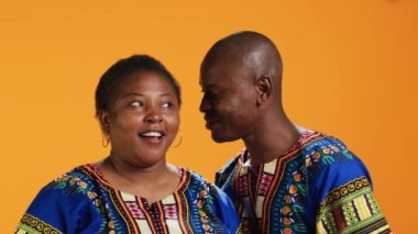 Neşeli bir adam karısıyla önemli bir sırrı paylaşıyor kulağına fısıldıyor ve dedikodu yapıyor. Şaşırmış bir kadın eğiliyor ve gizli bilgileri dinliyor, bağ kuruyor..