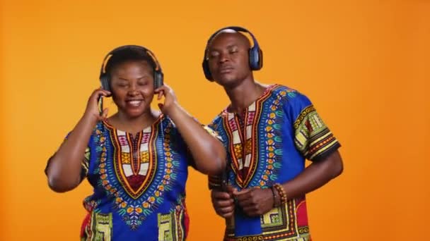 非裔美国人喜欢听音乐 在录音室里用耳机玩乐 快乐的男男女女在欢快的歌声中跳舞 在耳机上欣赏着曲调 — 图库视频影像
