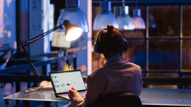 Bilgisayardaki çevrimiçi rapor için finansal grafikleri analiz eden, iş geliştirme için araştırma planı yazan odaklı bir çalışan. Geç saatlere kadar çalışan girişimci, yatırım ilerlemesini kontrol ediyor.