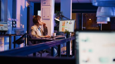 Girişimcilik ofisinde mali raporları okuyan kadın danışman iş karını artırmak için ekonomi grafiklerine bakıyor. Genç bir işçi yatırım planlarını kontrol ediyor, geceleri çalışıyor. El kamerasıyla..