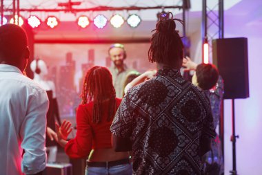 Çeşitli insanlar gece kulübündeki DJ performans partisinde dans pistinde takılıyor. Erkekler ve kadınlar klüp üyeleri diskoya katılıyor, dans ediyor ve müzik festivalinde gece hayatının tadını çıkarıyorlar.