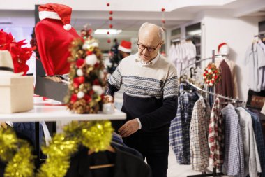 Yaşlı müşteri raflardaki eşyaları doğruluyor, Noel sezonu satışları sırasında kıyafet almak istiyor. Satılık mal arayan alıcı, aile ile tatil yemeği hazırlayan, xmas alışverişi.