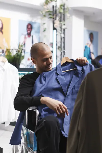 Comprador Árabe Sorridente Cadeira Rodas Segurando Jaqueta Corpo Examinando Vestuário — Fotografia de Stock