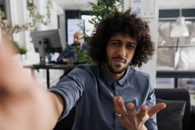 Şaşkın şirket ürün yöneticisi akıllı telefondan müşteriyle projeyi tartışıyor ve kameraya bakıyor. Girişimci analitik raporunu cep telefonundan müşteriye açıklıyor