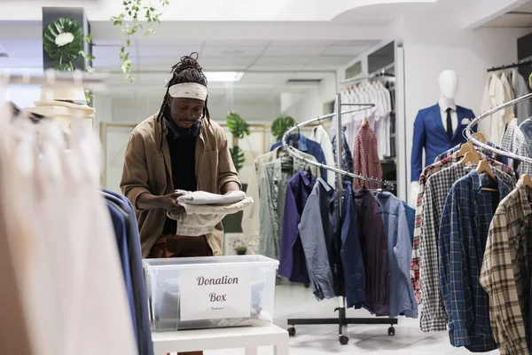 Afrikanischer Mann Steckt Kleidung Spendenbox Einkaufszentrum Modeboutique Kunde Packt Kleidung — Stockfoto