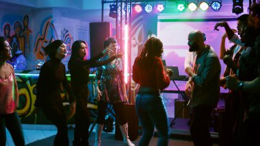 Diskotekte elektronik müzik sergilemek için dans eden funky insanlar, dansçılarla disko partisinde eğleniyorlar. Mutlu insanlar doğaçlama dans yarışması düzenliyor. El kamerasıyla..