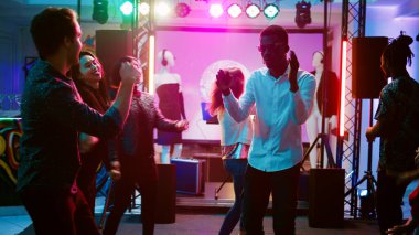 Kulüpte insanlarla dans eden mutlu bir adam diskotekte acayip havalı müzikle eğleniyor. Genç insan dans pistinde parti yapıyor, hoplayıp zıplıyor, barda sosyal bir toplantı yapıyor. El kamerasıyla..