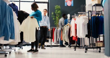 Modern butikte gömlek kumaşını analiz eden Afro-Amerikan müşteri, moda ürünler için alışveriş yapıyor. Giyim mağazasından yeni kıyafetler almak isteyen şık bir kadın. Moda konsepti