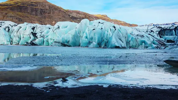 Large vatnajokull nordic ice cap next to frozen lake in icelandic landscape, majestic diamond shaped glacier in freezing cold winter scenery. Natural arctic icebergs and ice blocks. Handheld shot.