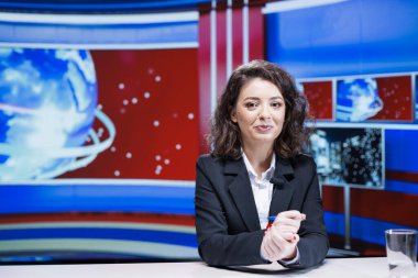 Televizyon kanalından canlı yayın yapan TV muhabiri medya haber odasından yayın yapıyor. Kadın gazeteci son olaylara değiniyor ve günlük uluslararası konuları kapsıyor.