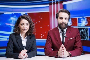 Manşetleri okuyan gazeteciler küresel televizyon kanalında sabah programındaki son haberleri tartıştılar. Dünyanın dört bir yanından önemli haberler sunan iki haber spikeri, televizyon içeriği.