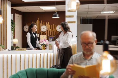 Bavullu yaşlı bayan misafir lüks otelin resepsiyonunda genç resepsiyonistle konuşuyor. Romanlı yaşlı adam otel lobisinde dinlenirken, yaşlı kadın resepsiyonda rezervasyon işlemi yapıyor..
