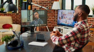 İnternette psikoloğa danışmak için video sohbet yoluyla aşırı çalışan ve tavsiye isteyen stresli bir tele-işçi. Uzaktan çalışan, şık ve rahat bir evden terapistle görüntülü görüşme yapan bir çalışan.