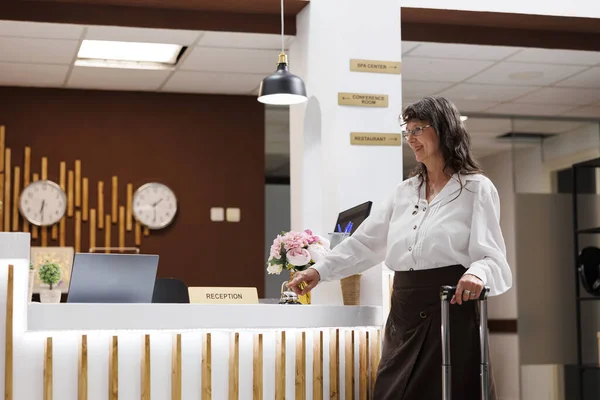 Senior Woman Reaches Registration Counter Rings Metallic Service Bell Asking — Stock Photo, Image
