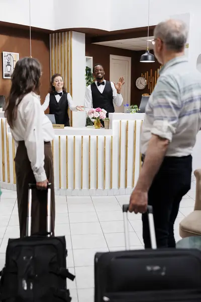Bělošský Starší Pár Vstupuje Hotelu Přistupuje Recepci Rezervační Pomocí Mnohonárodnostních — Stock fotografie