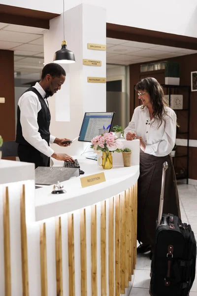 African American Receptionist Assists Old Woman Hotel Check Verifying Identity — Stock Photo, Image
