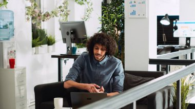 Profesyonel analist video çağrı konferansındaki proje verilerini, yönetim kuruluyla toplantıyı ve sunumu açıklıyor. Genç çalışan, internet üzerinden müdürle konuşuyor..