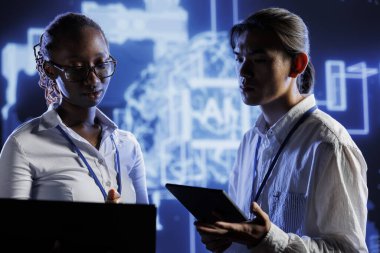 İş arkadaşları yapay zeka sinir ağlarını korumak için dizüstü bilgisayar ve tablet kullanıyorlar. Bilgisayarlı modeldeki insan düşünce süreçlerini taklit ediyorlar. Yapay zeka sistemlerini kontrol eden takım arkadaşları.