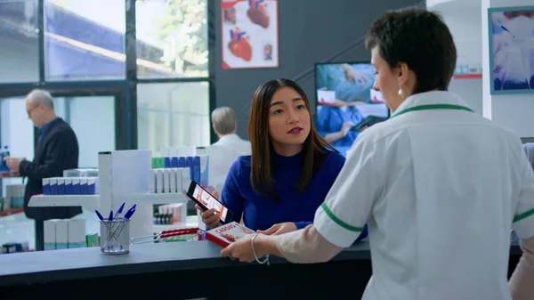 Client Asiatique Comptoir Pharmacie Montrant Pharmacien Prescrit Médecine Cardiaque Enquérir — Photo