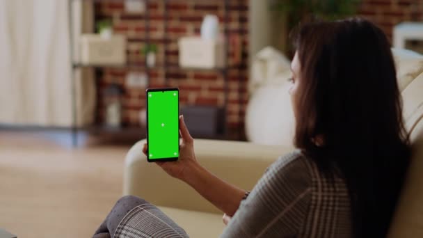 여자는 핸드폰에 동영상을 시간을 즐기는 아늑한 아파트에서 모크업 전화에 인터넷 — 비디오