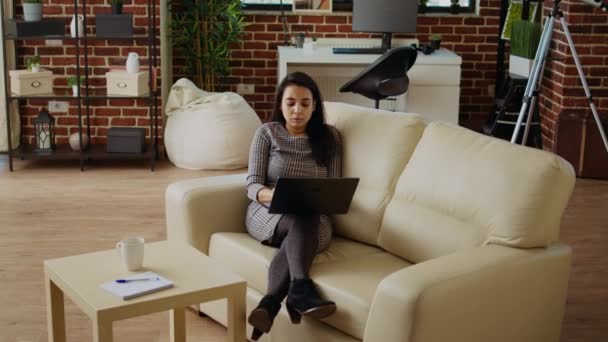 自营职业妇女在舒适的公寓里待在家里 专注于完成单调乏味的工作任务 在笔记本电脑键盘上自由打字的女商人 躺在沙发上 — 图库视频影像