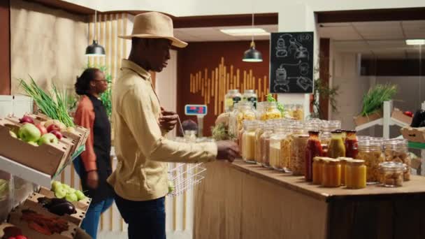 Afrikanisch Amerikanischer Kunde Kauft Pasta Oder Getreide Gläsern Und Betrachtet — Stockvideo
