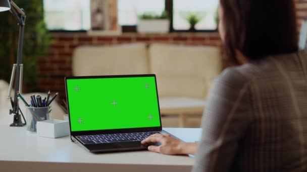 自由撰稿人在工作时从家里的电脑桌上查绿色屏幕笔记本电脑上的电子邮件 在舒适明亮的公寓里工作的自营职业妇女 在模拟装置上阅读商业信息 — 图库视频影像
