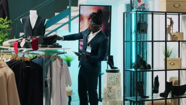 非洲裔美国人雇员在零售店为资深顾客提供建议 试图找到一件雅致的销售衬衫 老年客户向助理询问意见和建议 相机A — 图库视频影像