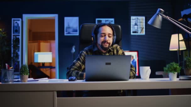 Keyifli Bir Adam Dizüstü Bilgisayarda Kulaklık Kullanarak Televizyon Izleyerek Evde — Stok video