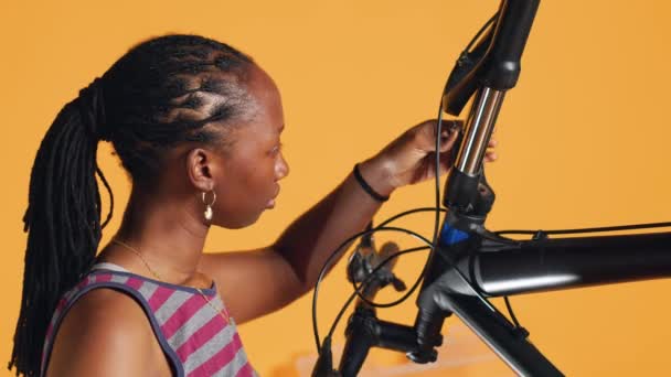 Bipocテクニシャンは スクリュードライバーを使用して自転車のハンドルをアンマウントし スタジオバックグラウンドのアトリエショップでコンポーネントの品質をテストします それらを修理するためのスペシャリストメカニックアンクリュー自転車の部品 カメラA — ストック動画
