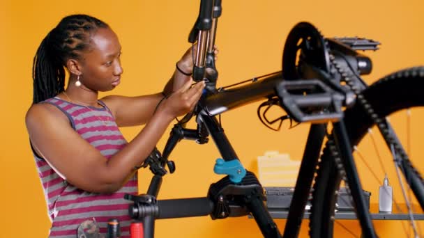 Bipoc技术人员使用螺丝刀卸下自行车把手 测试工作室背景工作室的组件质量 专业机械师拆开自行车零件以修补它们 照相机B — 图库视频影像