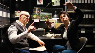 Ortaklar AR hologramını inceliyor, sanal görüntüyü yapay zekayla analiz ediyor. Dedektifler gelişmiş gerçeklik modern aksesuarlarıyla çalışıyor..