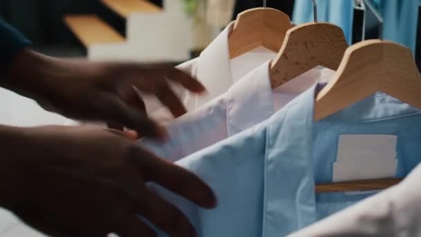 아프리카계 미국인 클라이언트는 옷걸이에 우아한 셔츠를보고 옷장을 공식적인 백화점에서 디자이너 — 비디오
