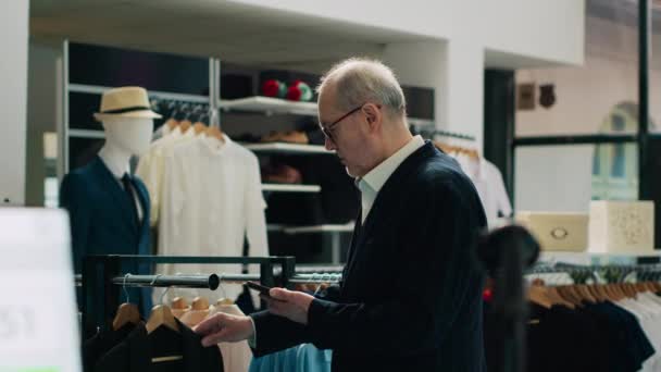 Традиционный Пожилой Человек Покупает Новую Модную Коллекцию Магазине Розничной Торговли — стоковое видео
